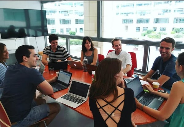Esta é uma imagem que mostra uma equipe em uma reunião em um ambiente corporativo
